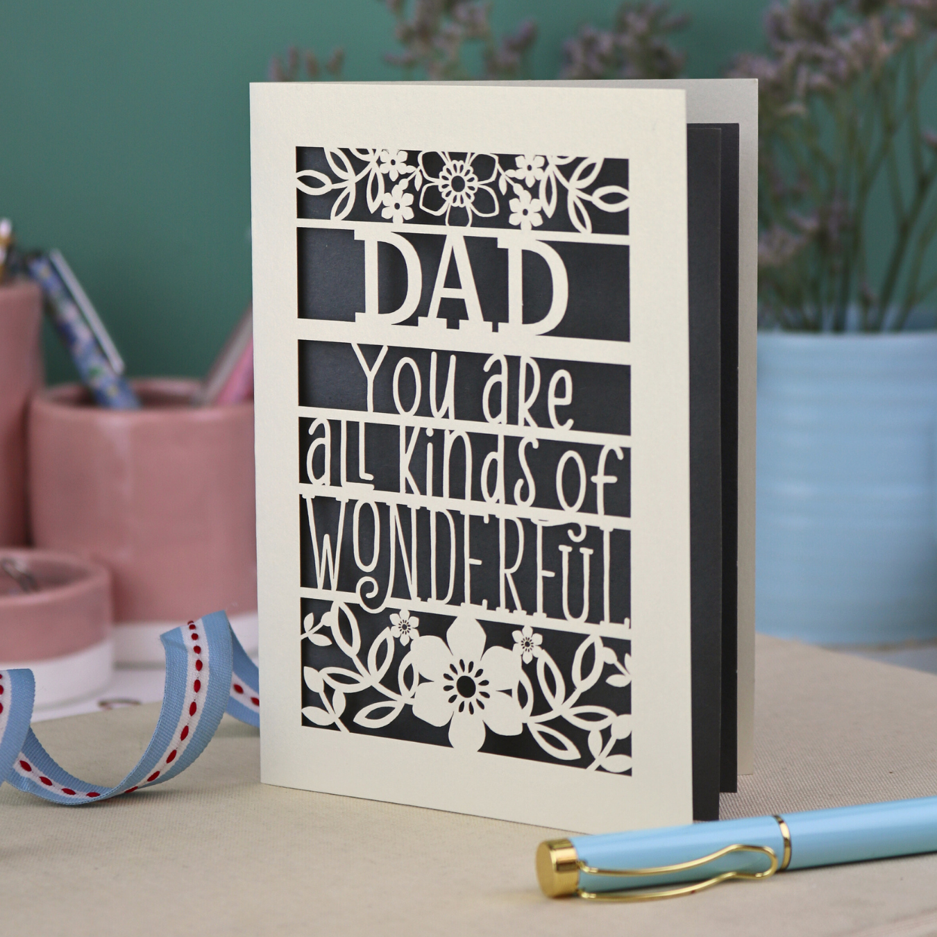 A laser cut cream Father's Day card, personalised with a name at the top, in this case, "Dad", and the text, "You are all kinds of wonderful"