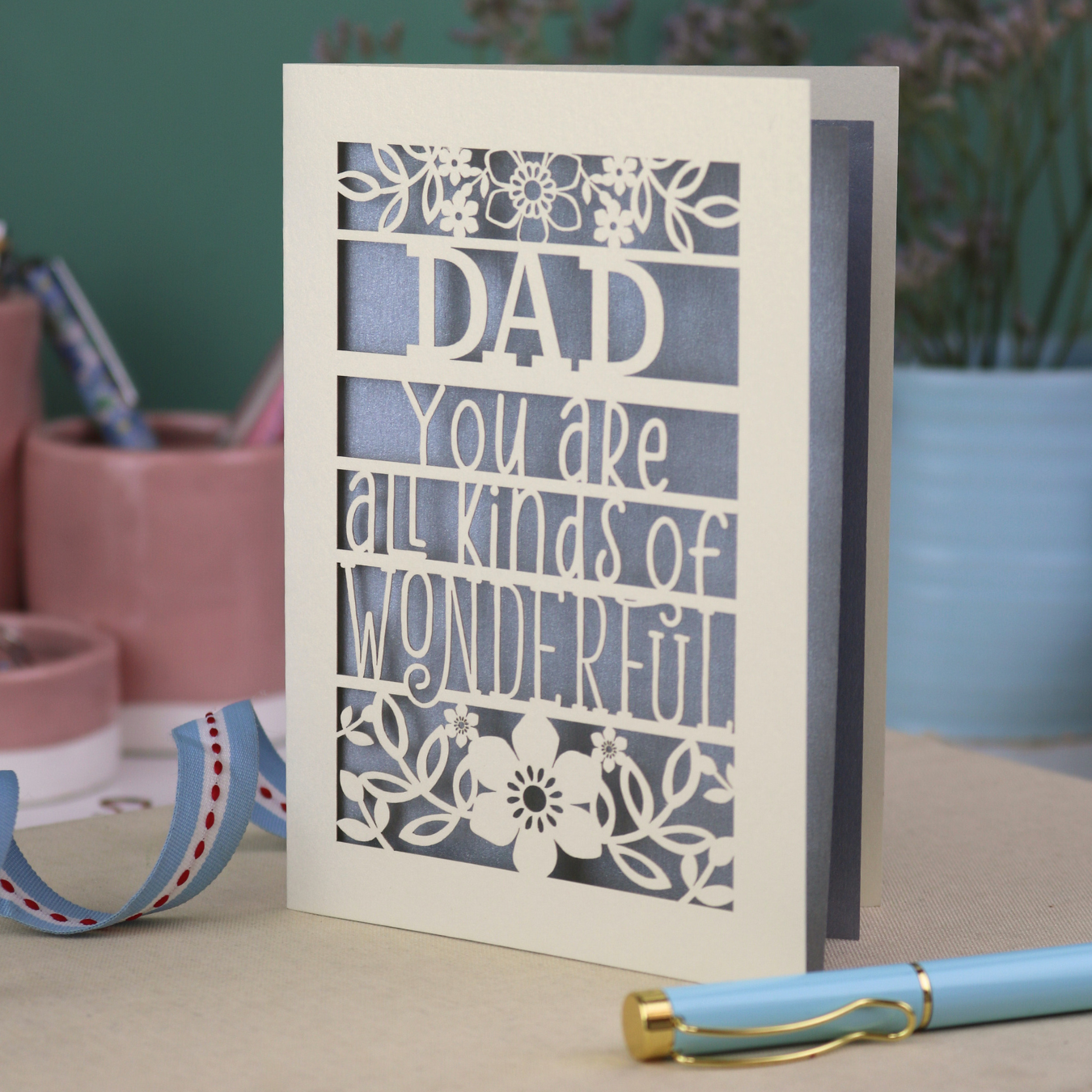 A laser cut cream Father's Day card, personalised with a name at the top, in this case, "Dad", and the text, "You are all kinds of wonderful"