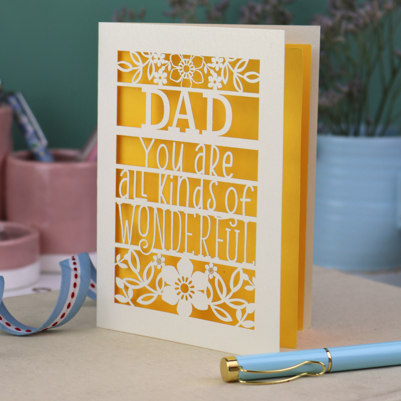 A laser cut cream Father's Day card, personalised with a name at the top, in this case, "Dad", and the text, "You are all kinds of wonderful"