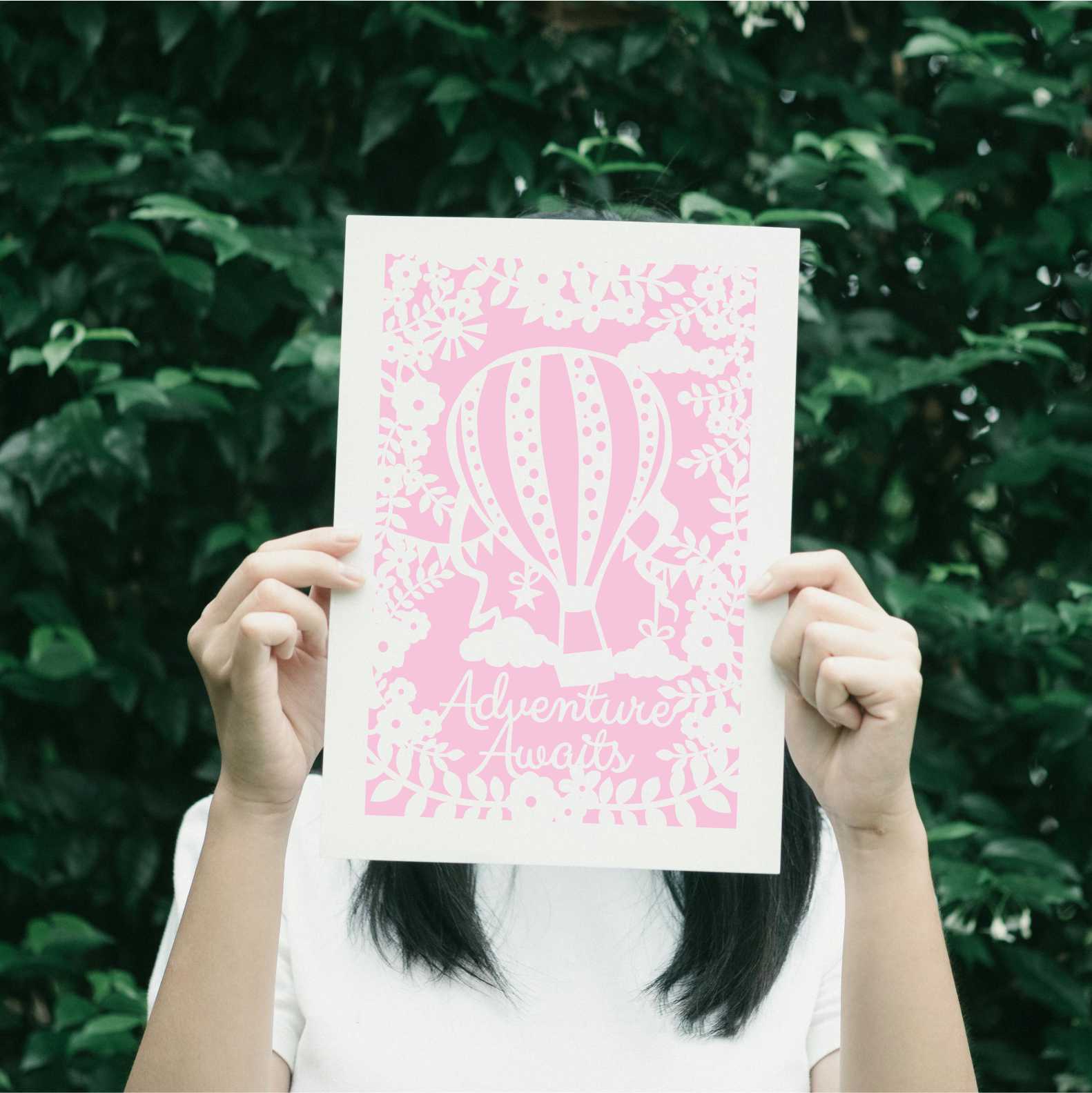 A candy pink print with a hot air balloon and the words "adventure awaits"
