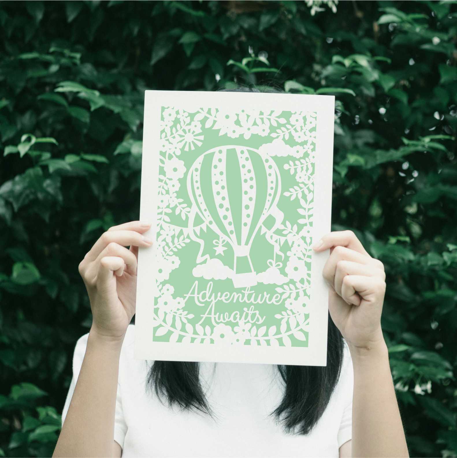 A spring green print with a hot air balloon and the words "adventure awaits"
