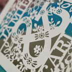 Decorative paper cutout with floral patterns on a blue background