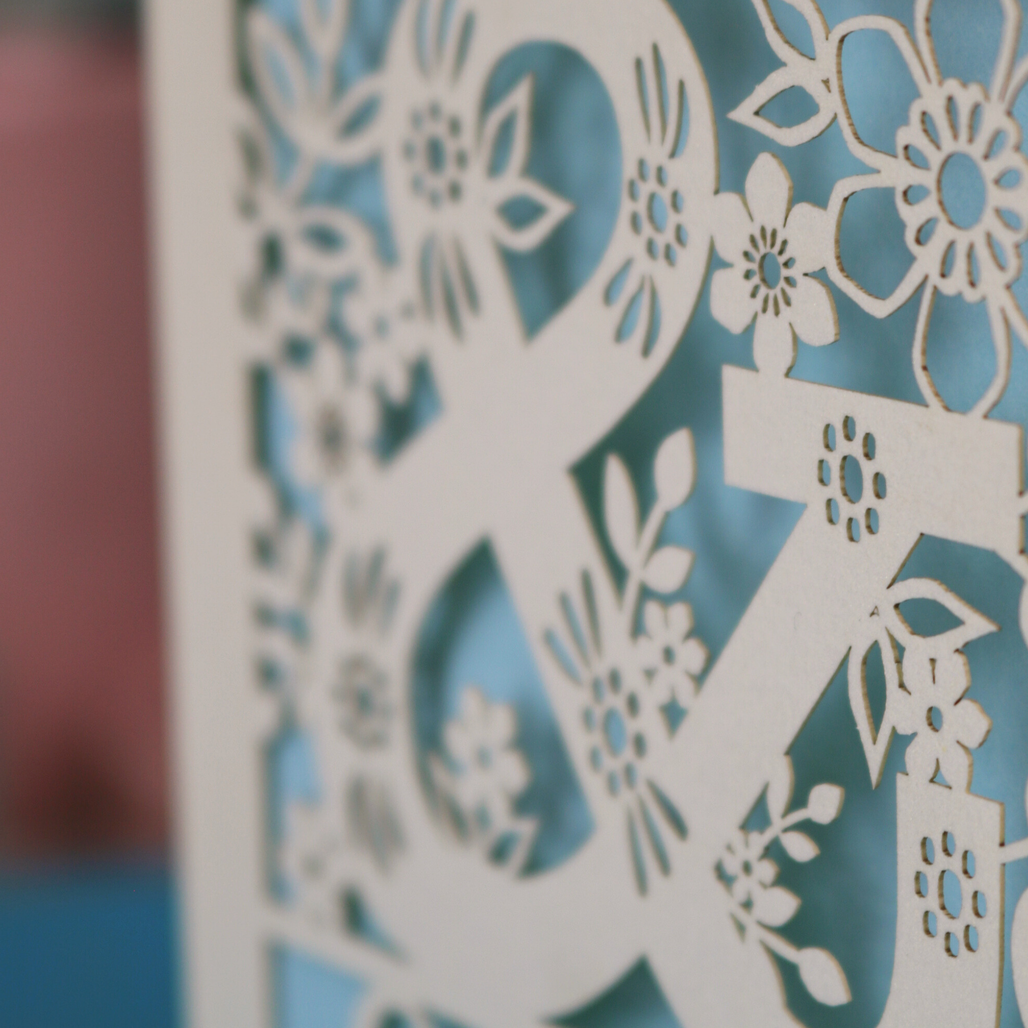Decorative paper cutout with floral patterns on a blue background
