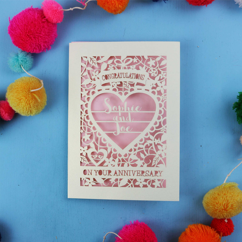 Laser cut Personalised wedding anniversary card with decorative heart design on a blue background with colourful pom-poms.