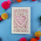 Laser cut Personalised wedding anniversary card with decorative heart design on a blue background with colourful pom-poms.