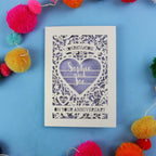 Personalised wedding anniversary card with decorative heart design on a blue background with colourful pom-poms.