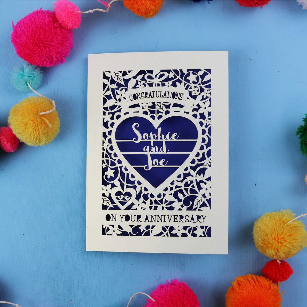 Personalised wedding anniversary card with decorative heart design on a blue background with colourful pom-poms.