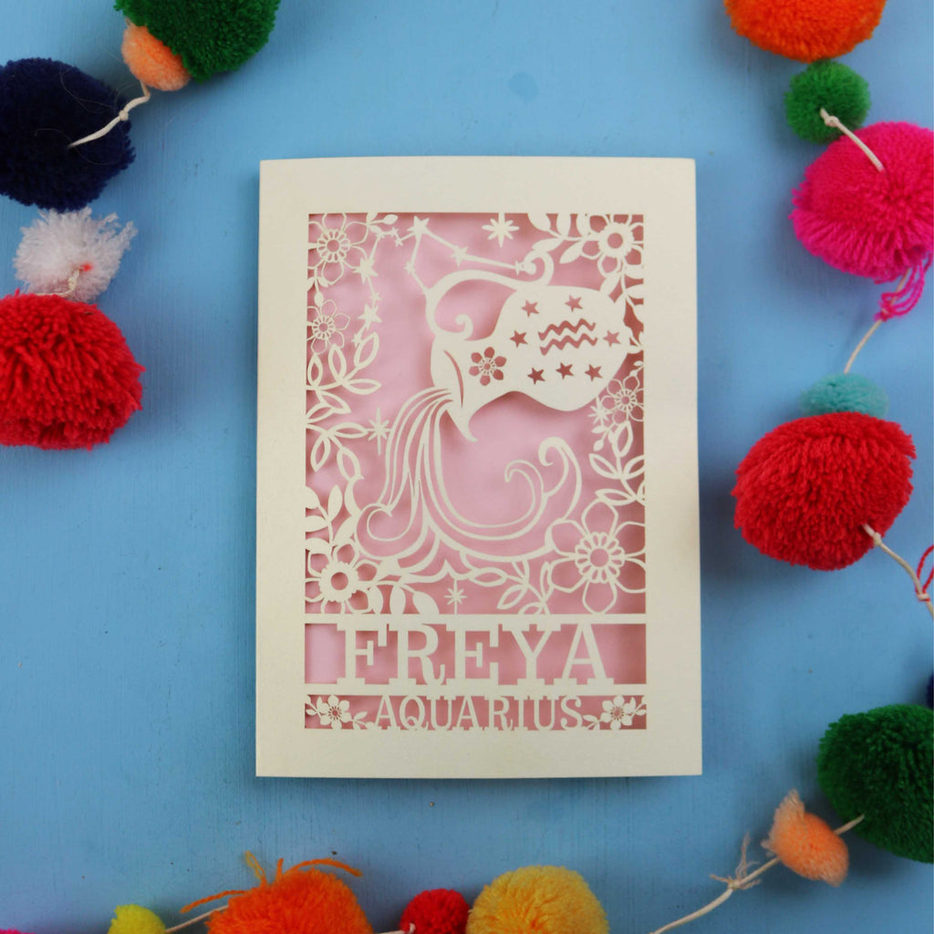 Decorative Aquarius Birthday card with 'FREYA AQUARIUS' design on a blue background with colourful pom-poms.