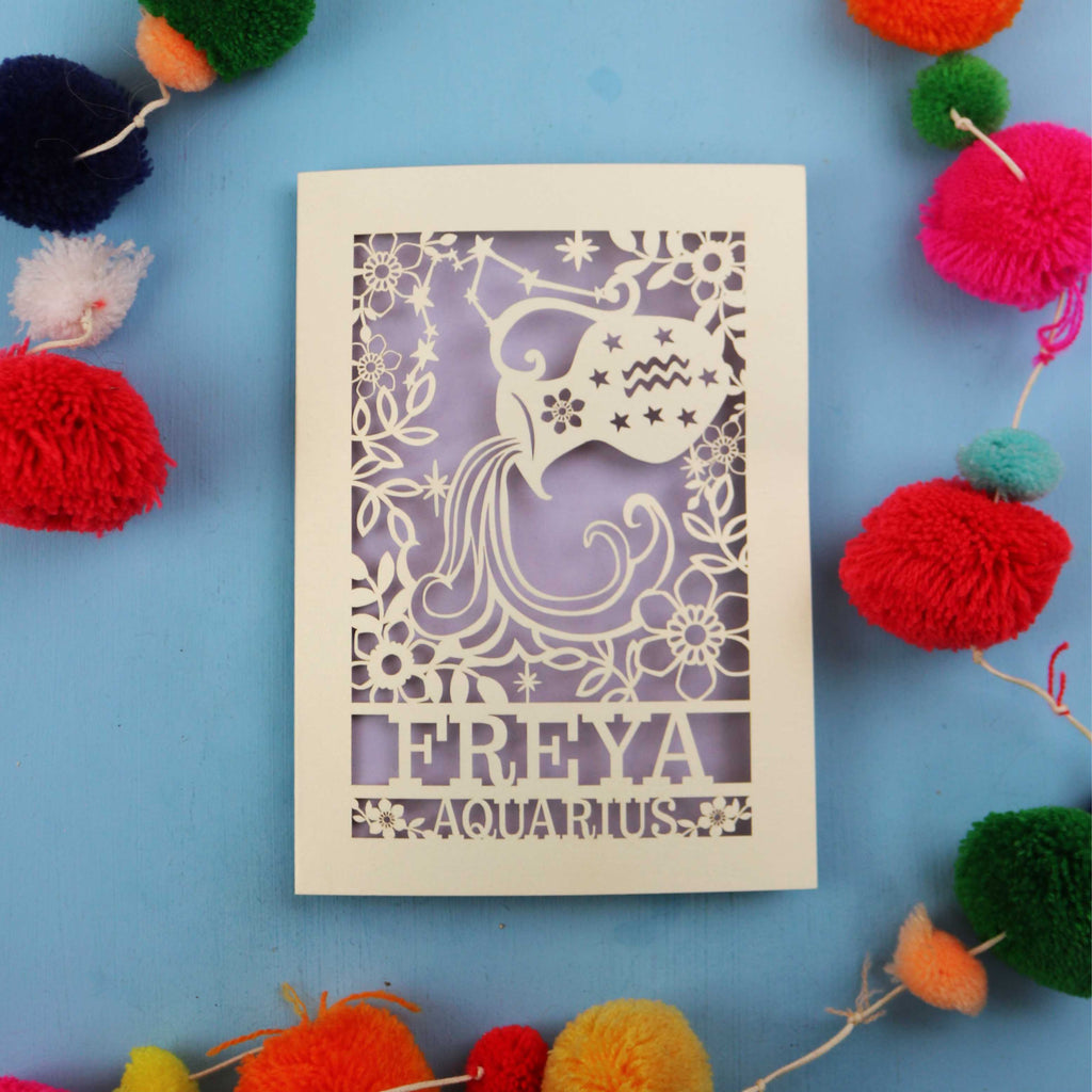 Decorative Aquarius Birthday card with 'FREYA AQUARIUS' design on a blue background with colourful pom-poms.