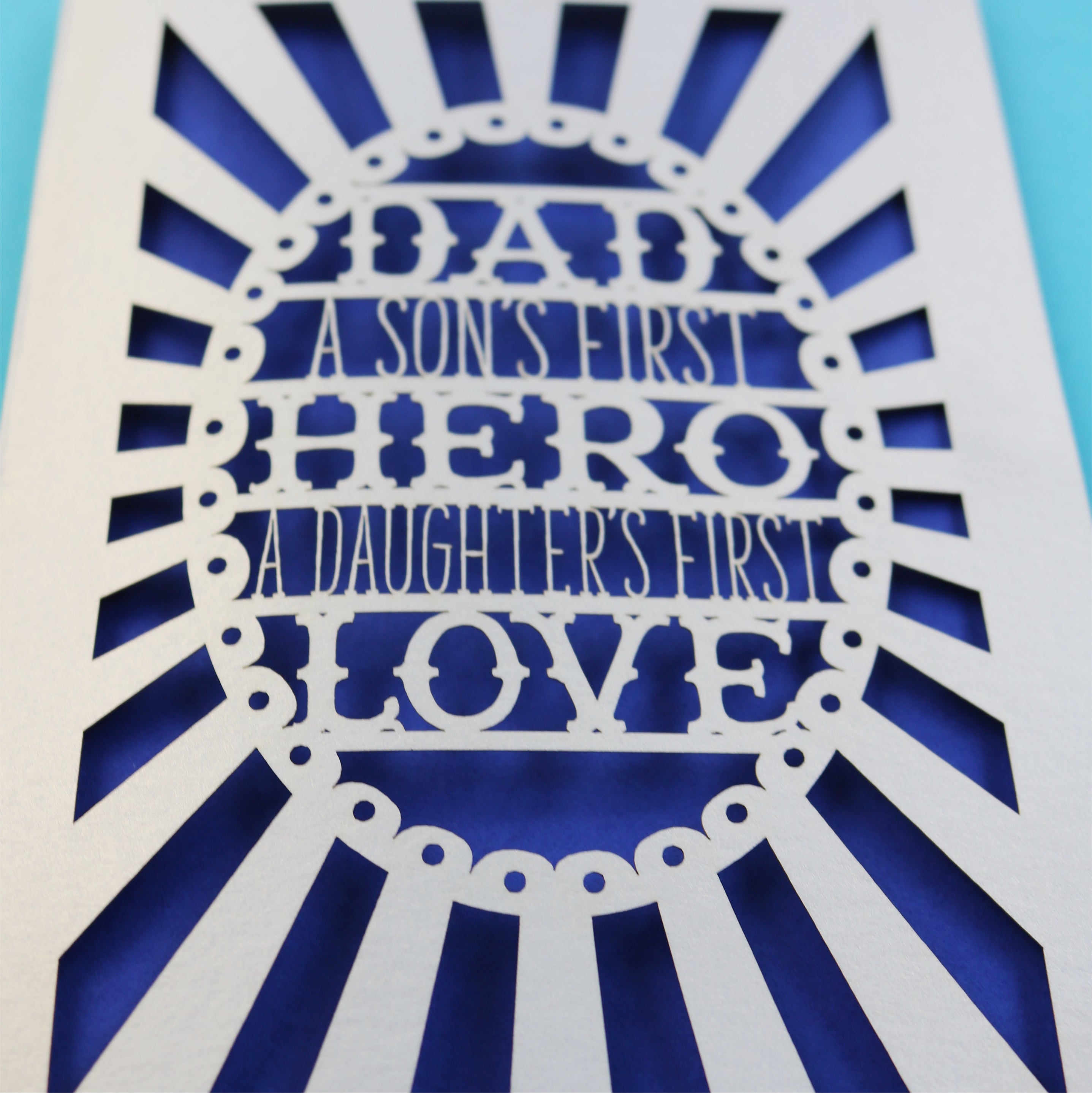A unique laser cut father's day card that says "Dad, A son's first hero, a daughter's first love"