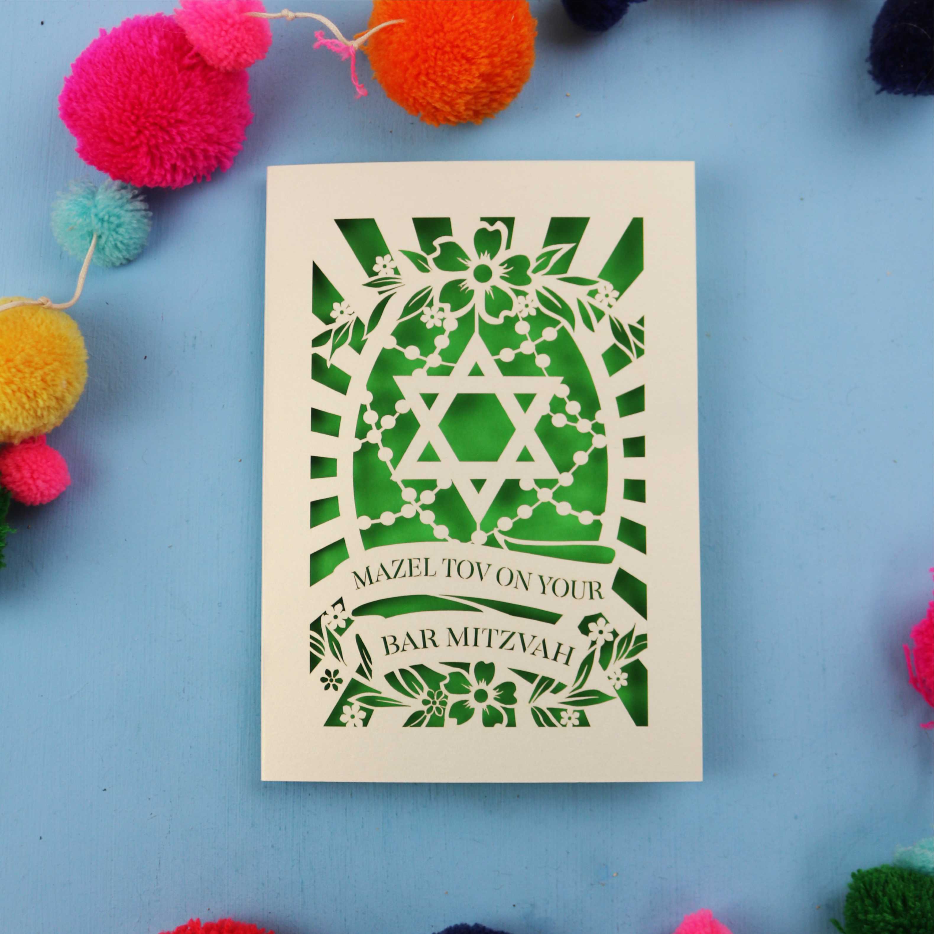 Cut Out Bar Mitzvah card with Star of David design on a blue background with colourful pom-poms.