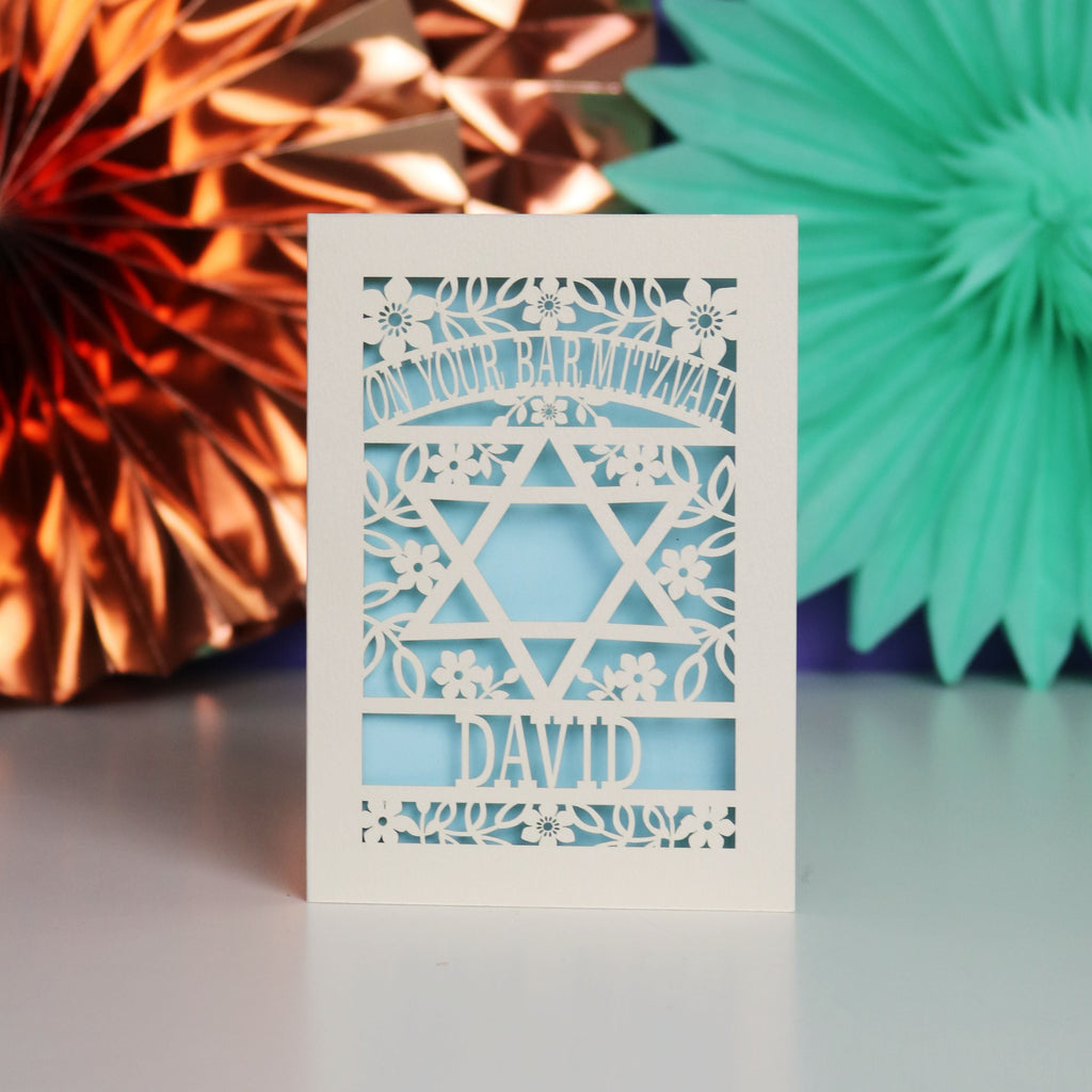 A personalised paper cut Bar Mitzvah card that says "On Your Bar Mitzvah, Name"