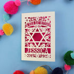 Personalised laser cut Bat Mitzvah card with Star of David design on a blue background with colourful pom-poms.