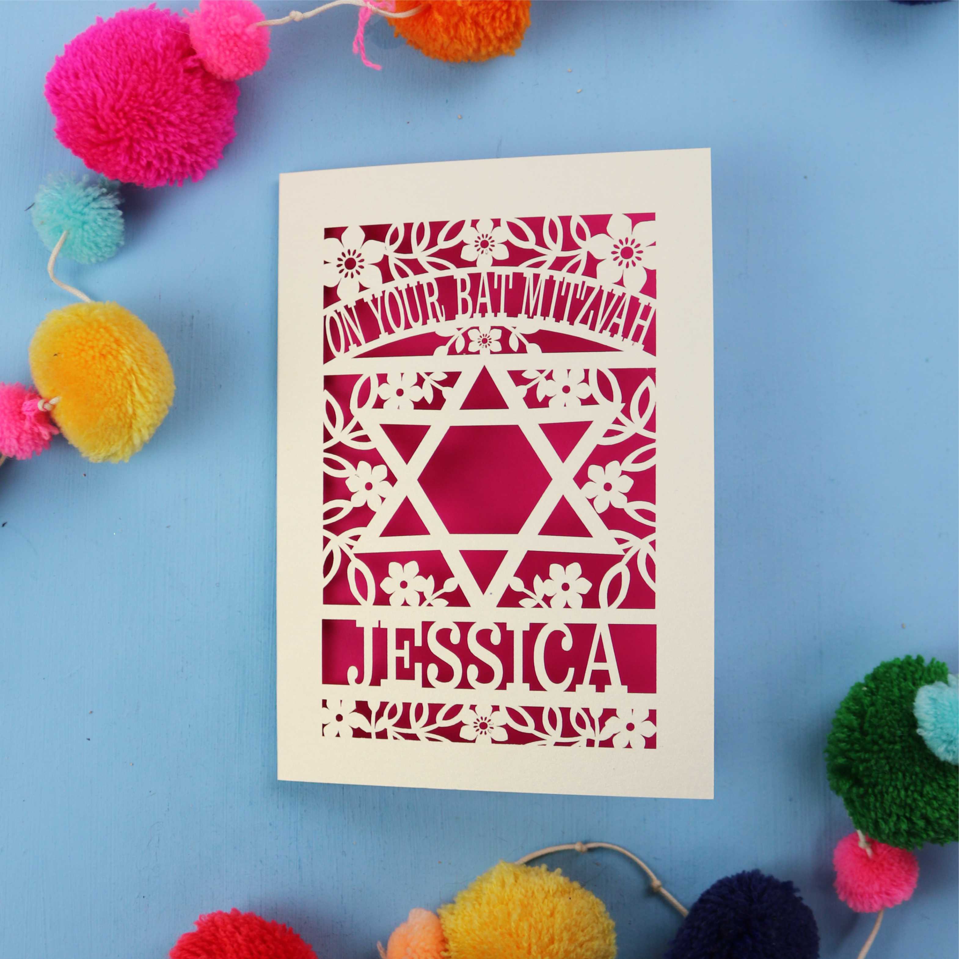 Personalised laser cut Bat Mitzvah card with Star of David design on a blue background with colourful pom-poms.