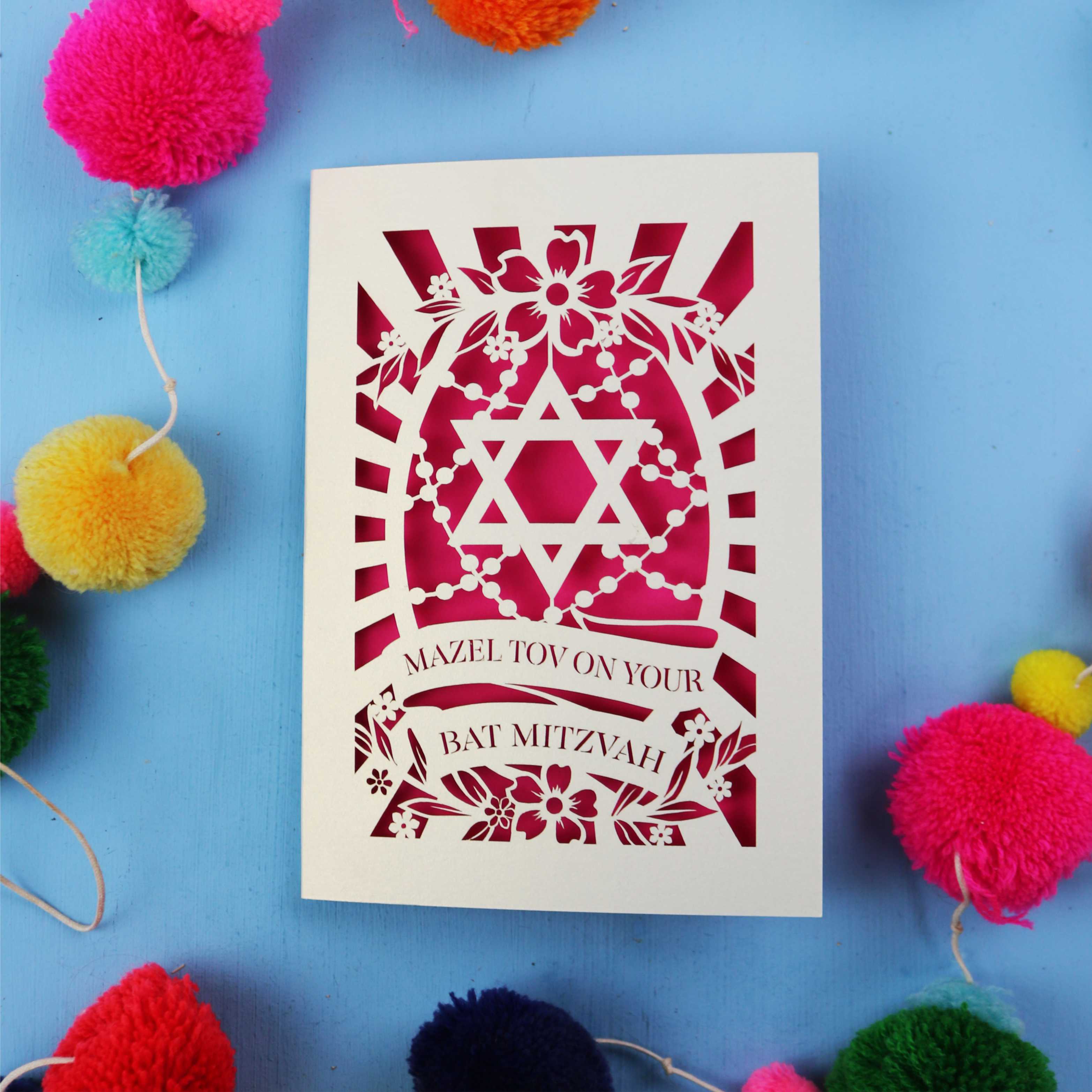 Cut out Bat Mitzvah card with Star of David design on a blue background with colourful pom-poms.