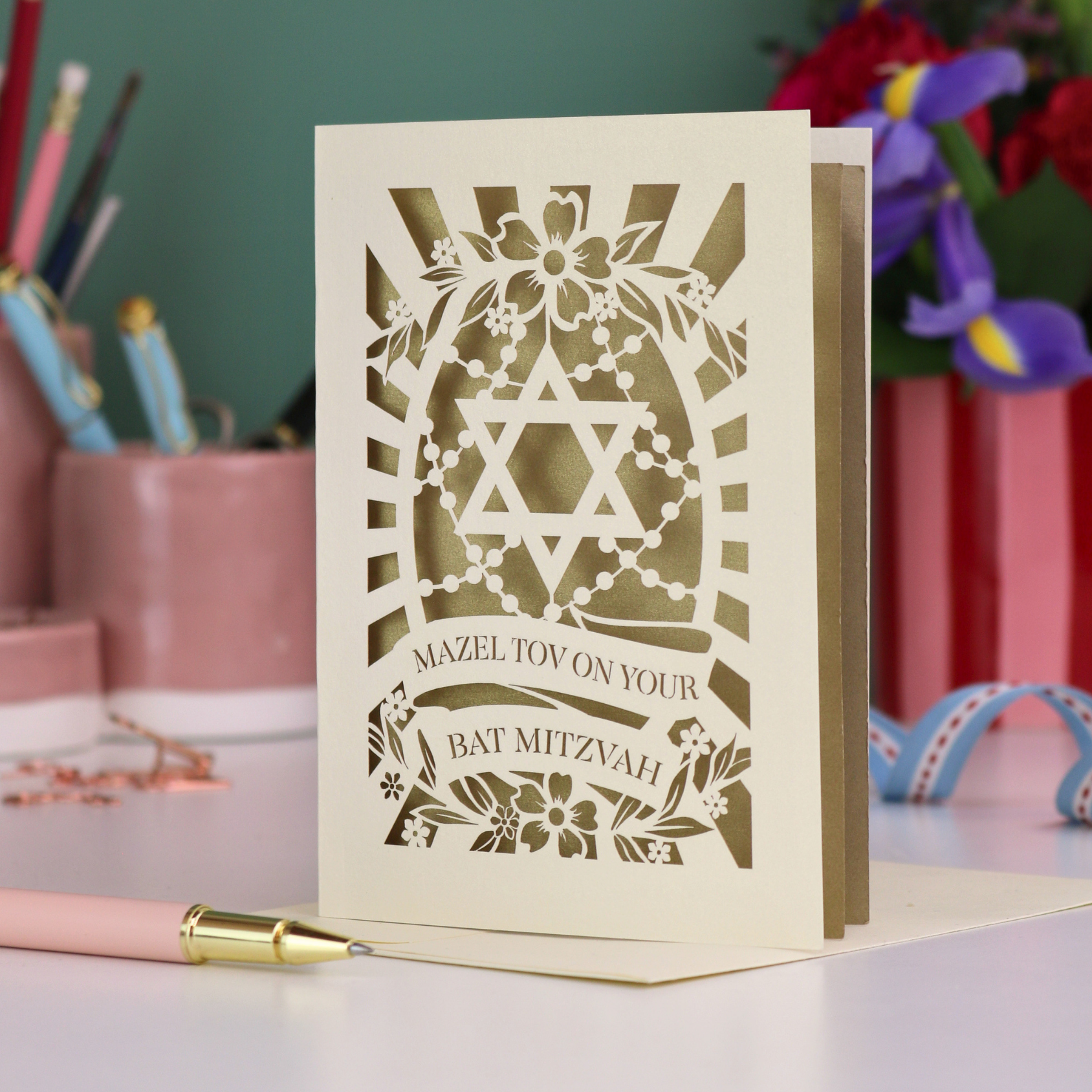 Bat Mitzvah card with Star of David design on a desk with stationery items.
