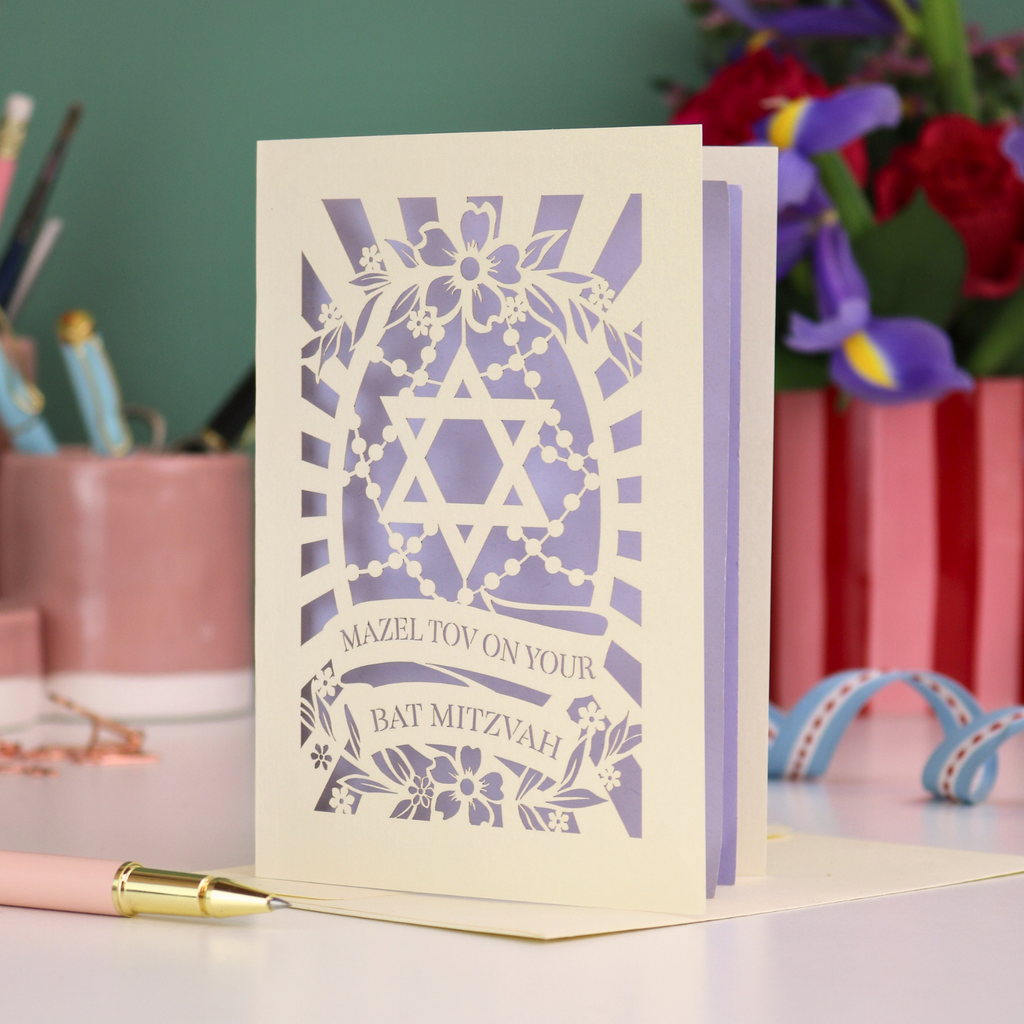 Bat Mitzvah card with Star of David design on a desk with stationery items.