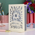 Bat Mitzvah card with Star of David design on a table with flowers and candles.
