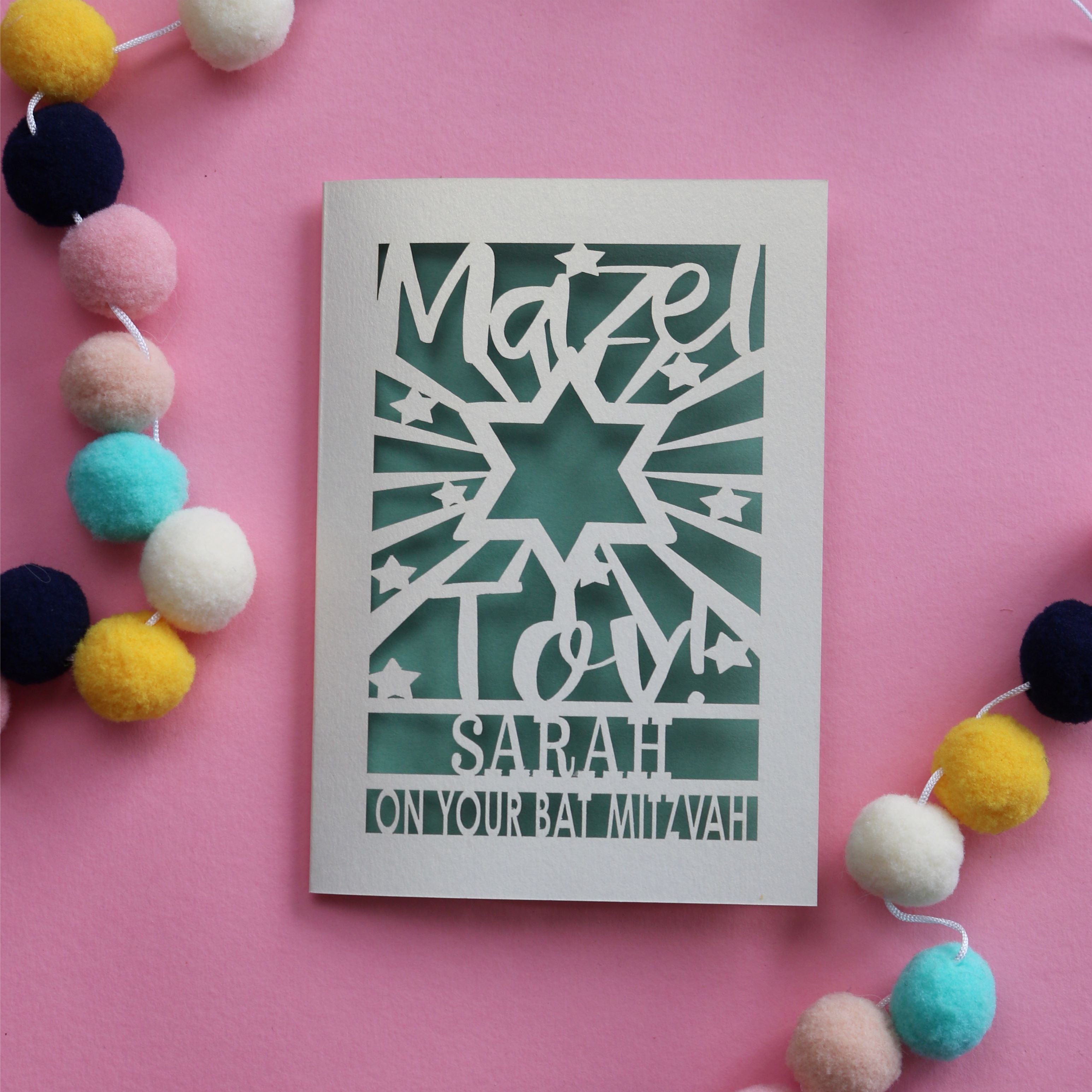 A personalised laser cut Bat Mitzvah card that says Mazel Tov, Name, on your Bat Mitzvah 