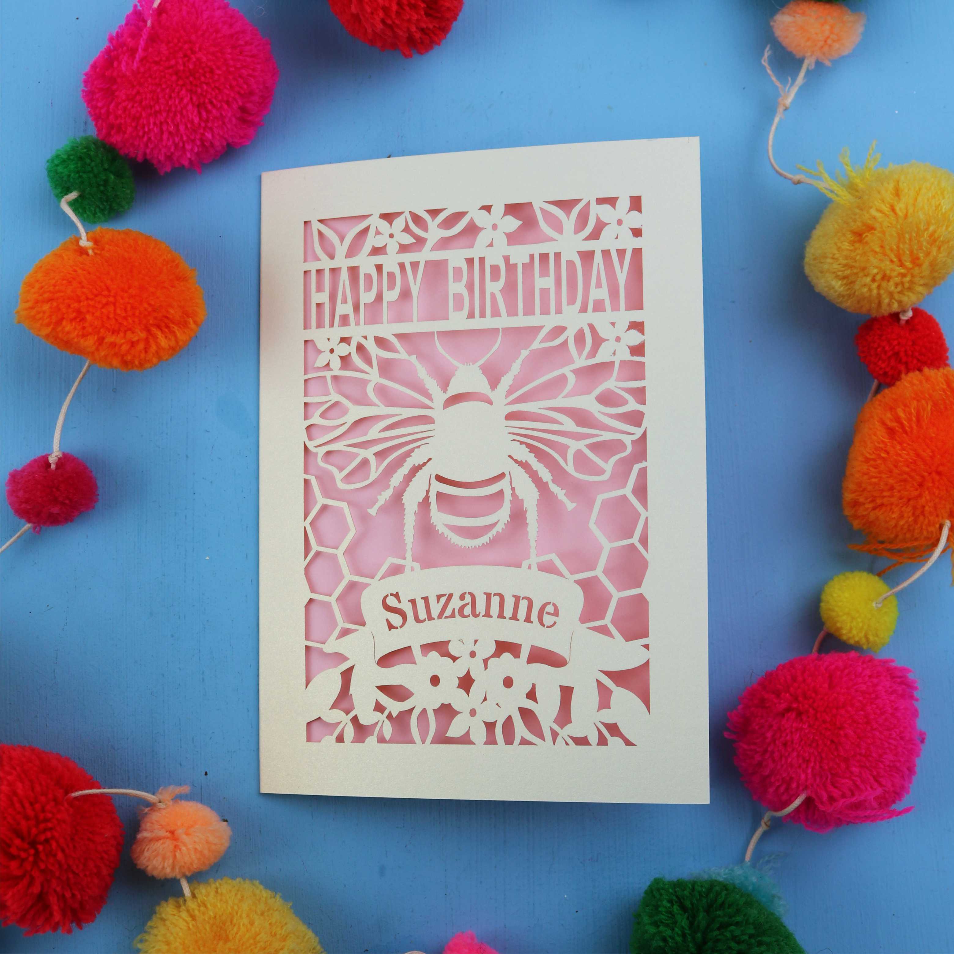 Birthday card with bee design and colourful pom-poms on a blue background