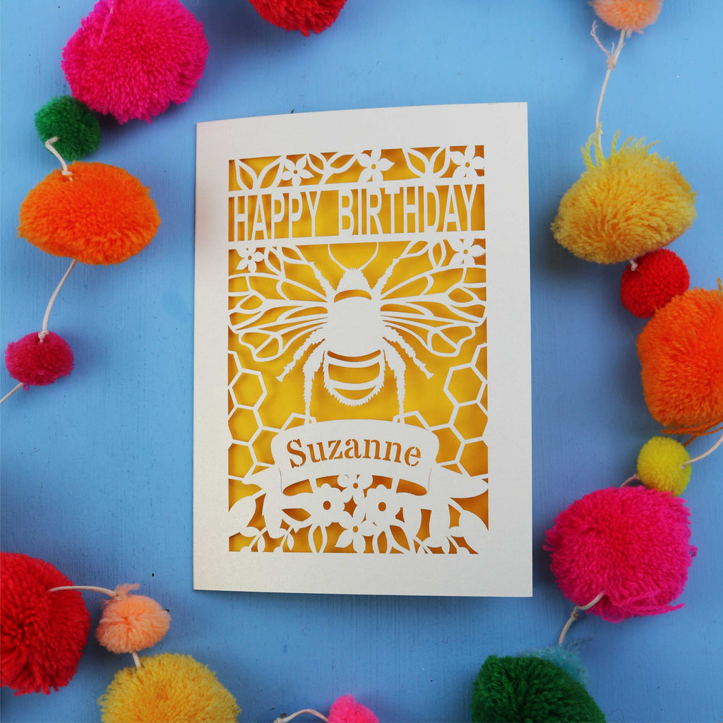 Birthday card with bee design and colourful pom-poms on a blue background