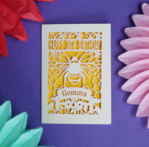 Personalised papercut birthday card showing a cut out of a bee. Has Happy 30th Birthday and a space for a name.  Laser cut from cream card and given a sunshine yellow insert paper.