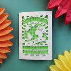 A paper cut Father's Day card with a cut out of the world and the words "Happy Fathers Day to the best dad in the whole world"