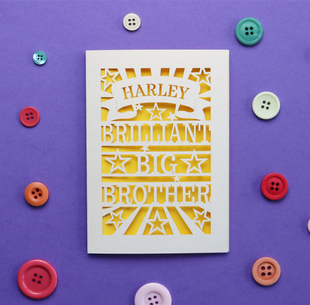 Laser cut greetings card with 'Harley Brilliant Big Brother' text on a purple background with colourful buttons