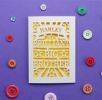 Laser cut greetings card with 'Harley Brilliant Big Brother' text on a purple background with colourful buttons