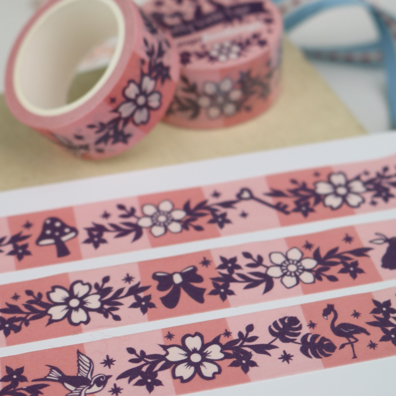 Decorative tape with floral and nature-themed designs on a pink background
