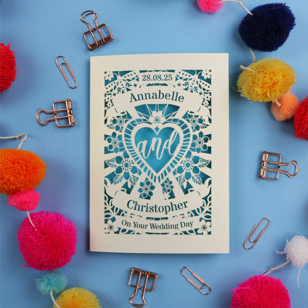 Personalized laser cut wedding card with decorative elements on a blue background