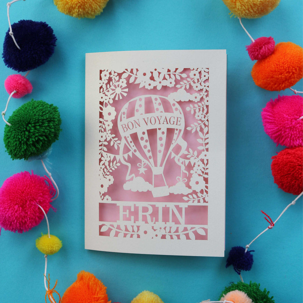 A cut out card with Bon Voyage and a name.