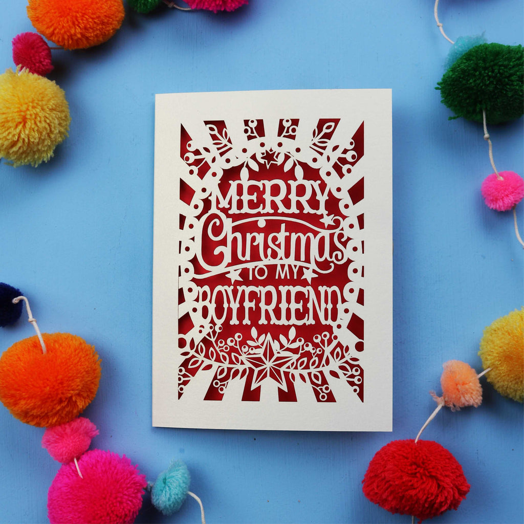 Decorative Boyfriend Christmas card with 'Merry Christmas to my boyfriend' text on a blue background with colourful pom-poms.