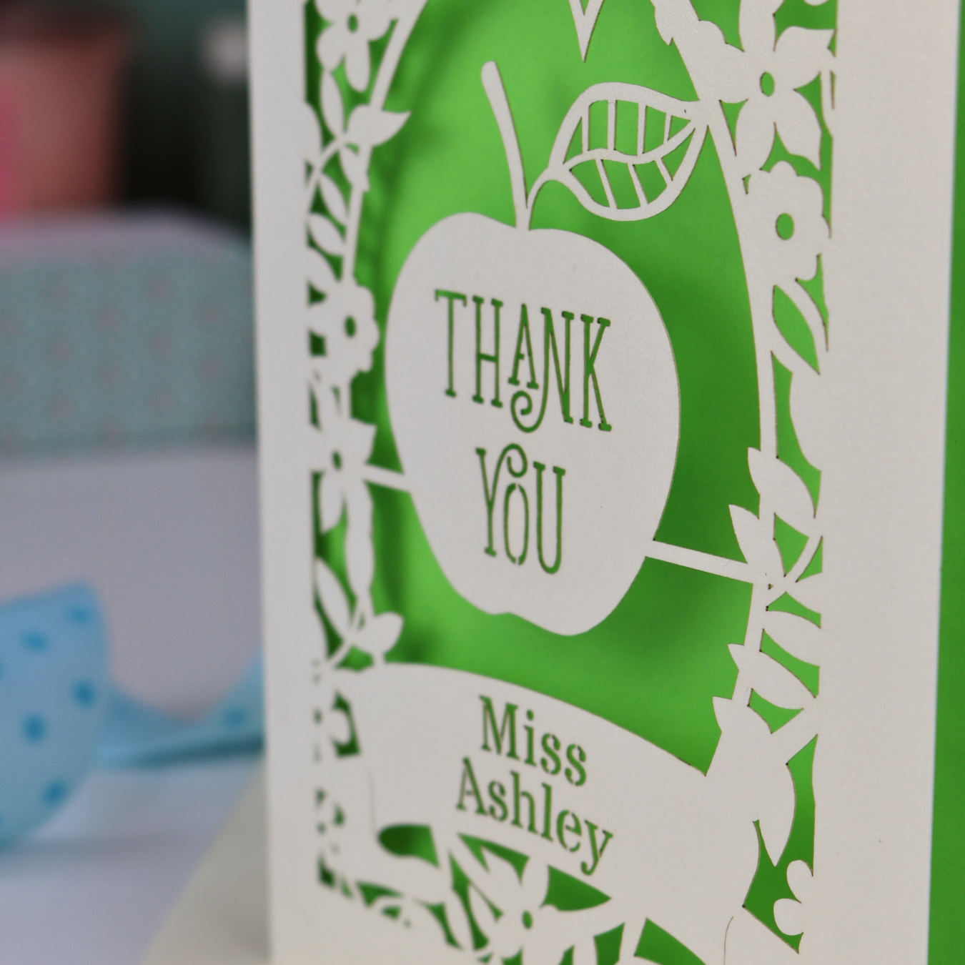 Thank you teacher card with apple design, decorative border and text, 'Thank You Miss Ashley'