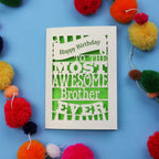 Laser cut brother Birthday card for the most awesome brother ever on a blue background with colourful pom-poms.
