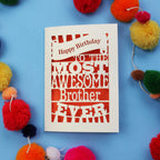 Laser cut brother Birthday card for the most awesome brother ever on a blue background with colourful pom-poms.