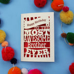 Laser cut brother Birthday card for the most awesome brother ever on a blue background with colourful pom-poms.