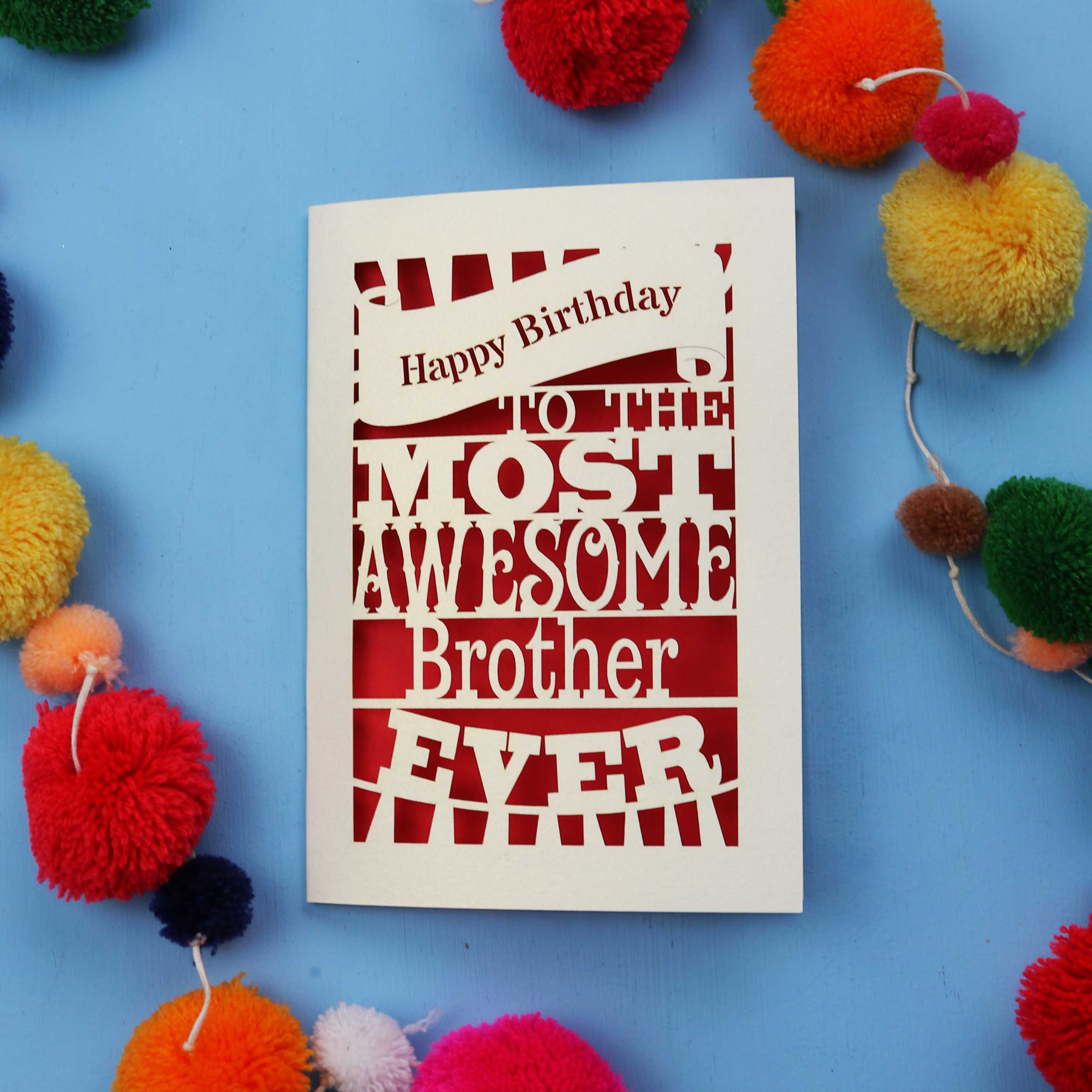 Laser cut brother Birthday card for the most awesome brother ever on a blue background with colourful pom-poms.