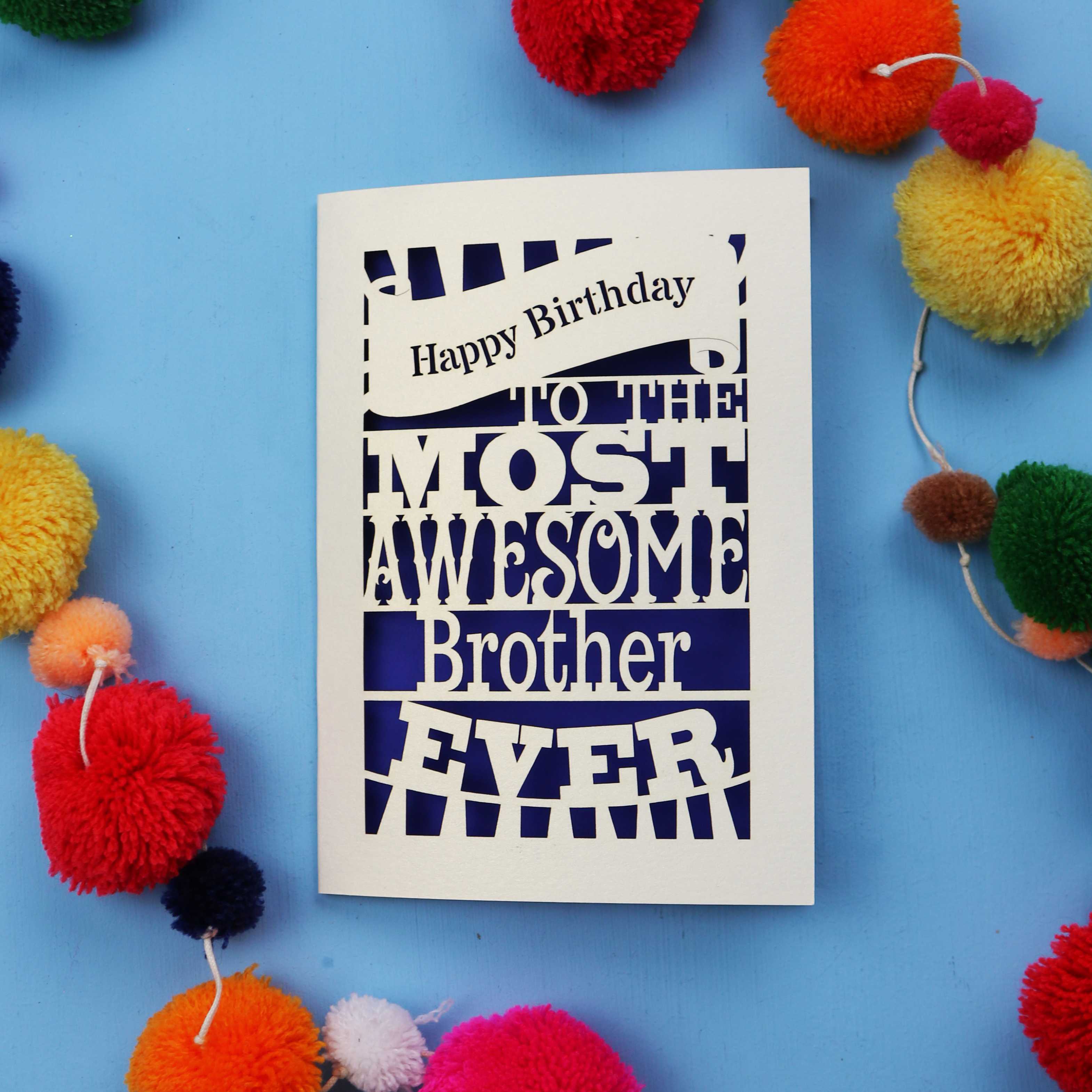 Laser cut brother Birthday card for the most awesome brother ever on a blue background with colourful pom-poms.