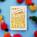 Laser cut brother Birthday card for the most awesome brother ever on a blue background with colourful pom-poms.