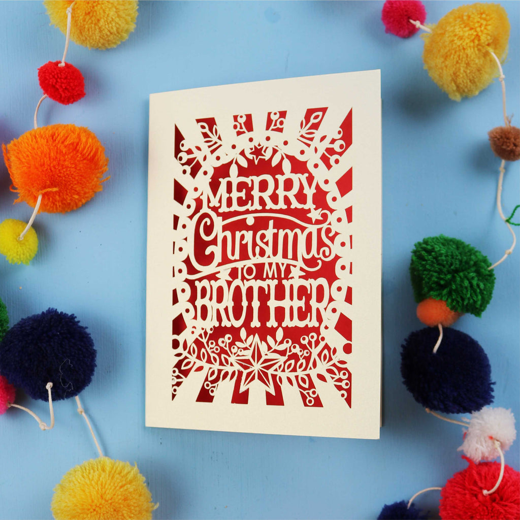 Brother Christmas card with 'Merry Christmas to my brother' text on a blue background with colourful pom-poms.