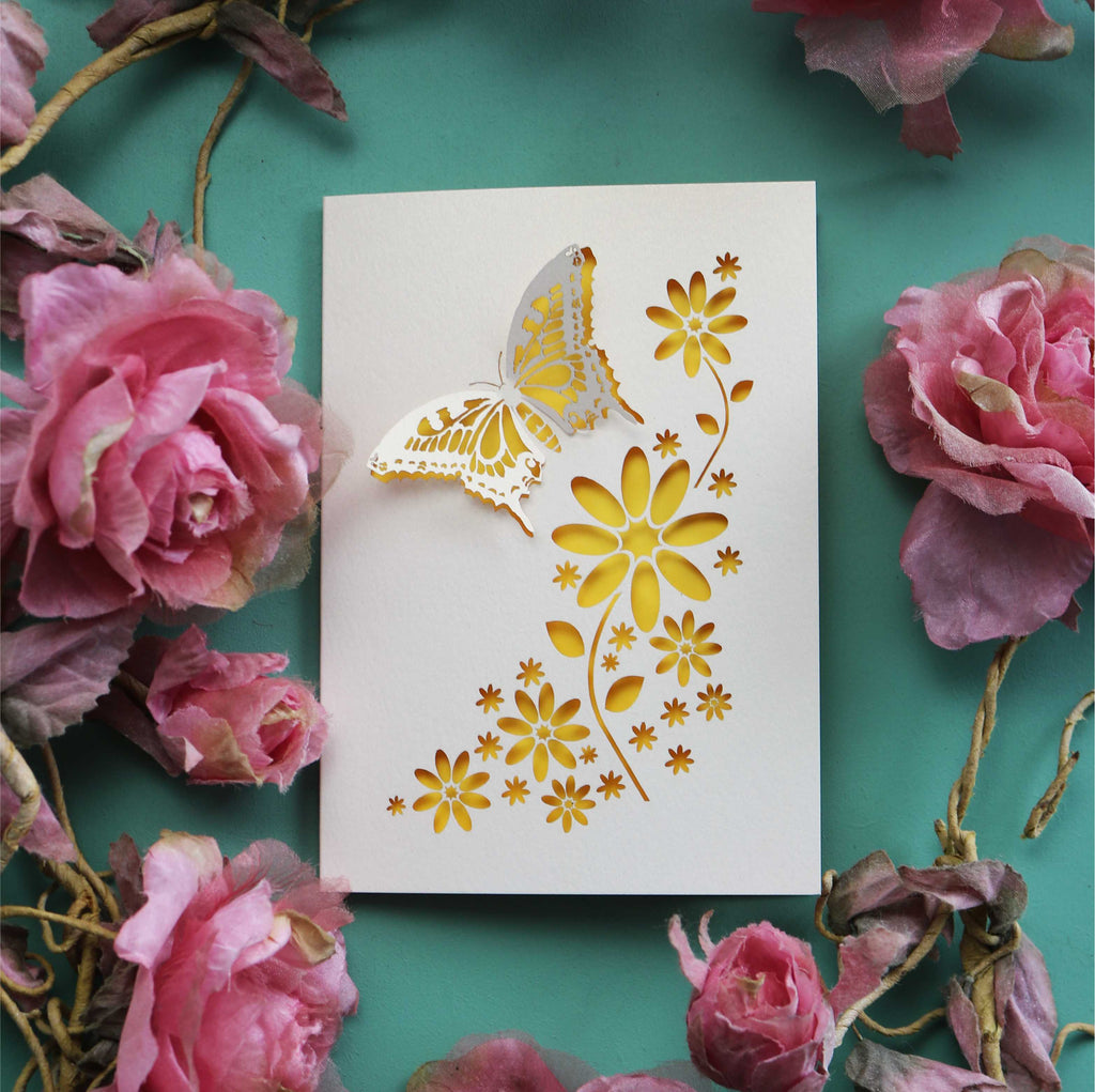 A greeting card with 3D laser cut butterfly and cut out flower shapes