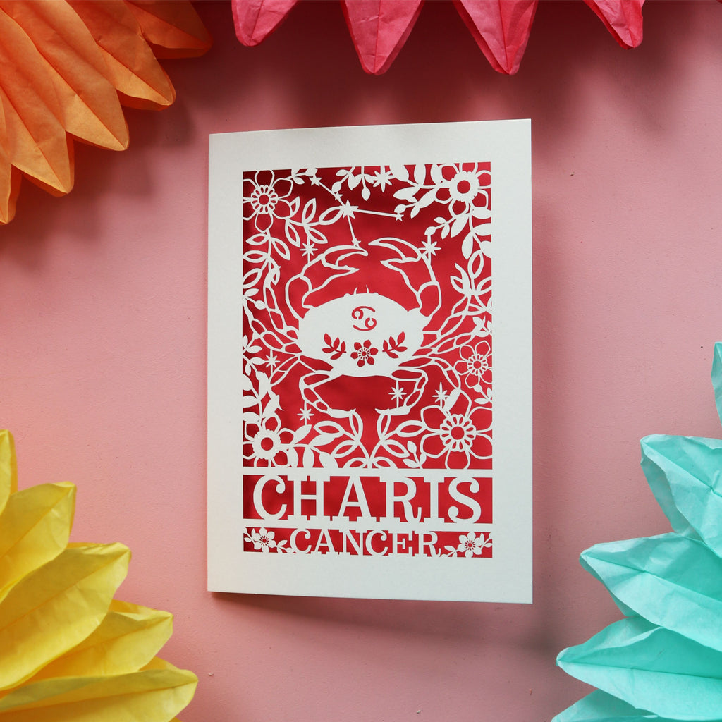 A laser cut birthday card for Cancerians, personalised with their name. Card features a cut out crab, constellation and star sign symbol