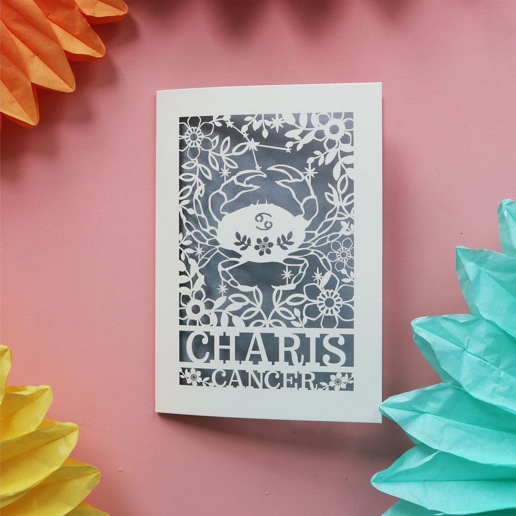 A birthday card for cancer zodiac signs. Card has a crab surrounded by flowers and features the recipient's name
