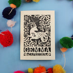 Decorative cut out star sign birthday card with Capricorn zodiac symbol on a blue background with colourful pom-poms.