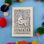 Decorative birthday card with Capricorn zodiac symbol on a blue background with colourful pom-poms.