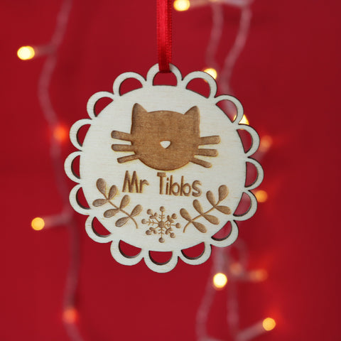 a wooden laser engraved decoration featuring a cat's face and a name.
