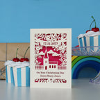 A papercut Christening card personalised and featuring a cute church surrounded by leaves and flowers. 