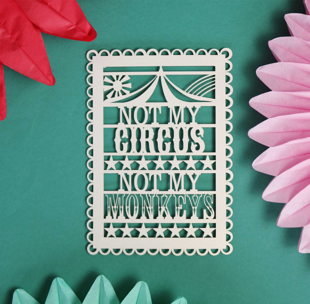 A papercut postcard that reads "Not my circus, not my monkeys"