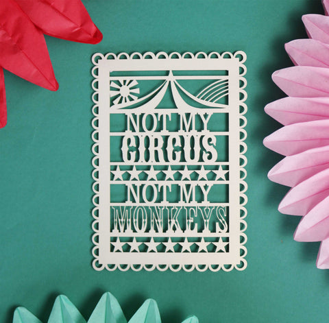 A papercut postcard that reads "Not my circus, not my monkeys"